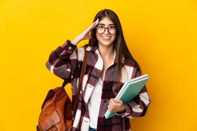 Young student woman isolated on yellow wall with surprise expression