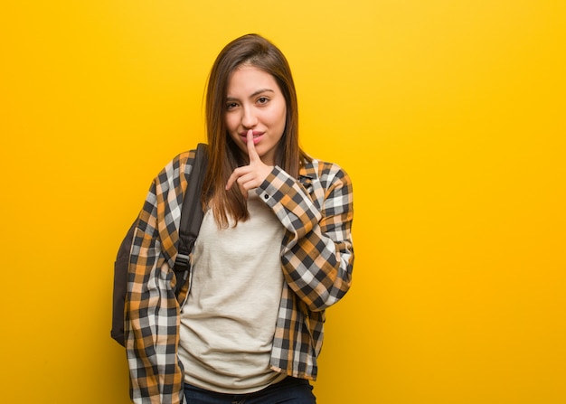 Young student woman keeping a secret or asking for silence