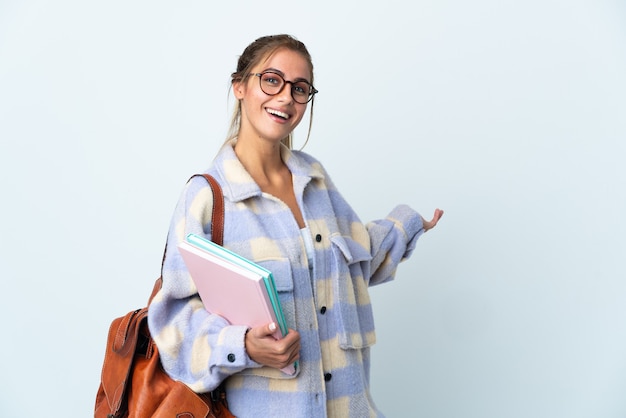 Young student woman posing isolated against the blank wall