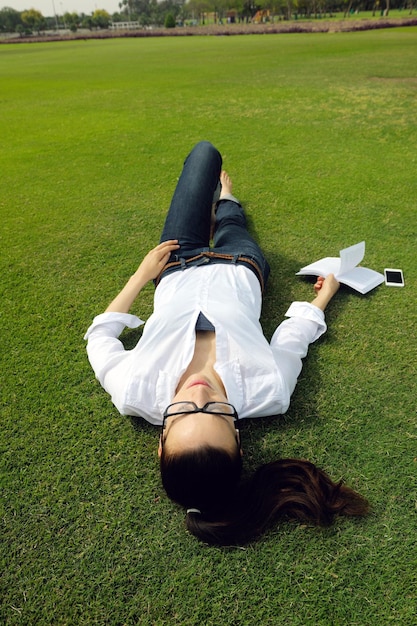 Photo young student woman reading a book and study in the park