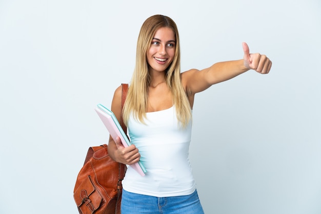 Young student woman on white giving a thumbs up gesture