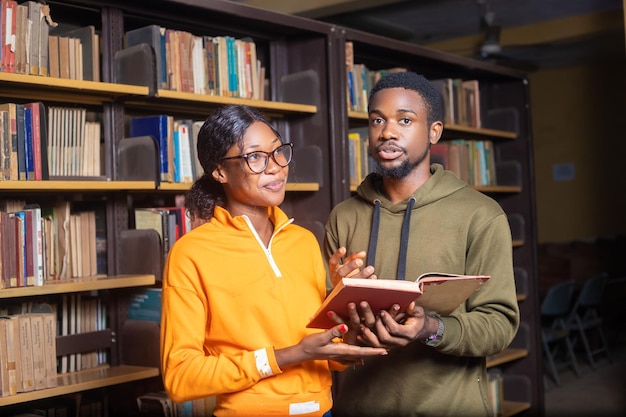 Young students holding a book in a library