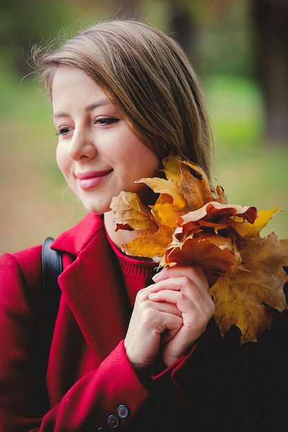 Young style girl with leaves in park alley