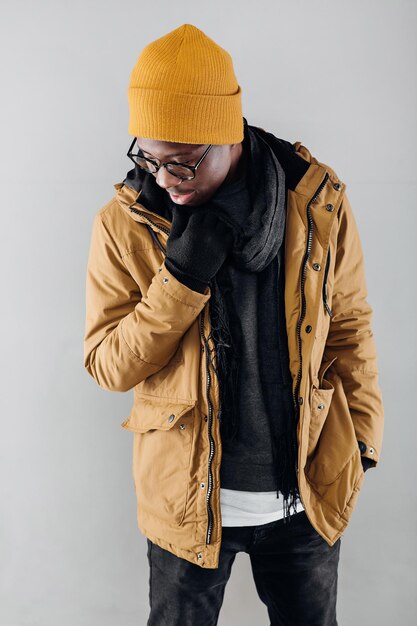 Photo young stylish african-american man in yellow hat and jacket posing on gray background