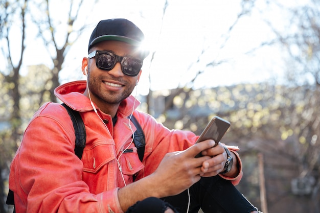 Young stylish afro american man in cap and leather jacket