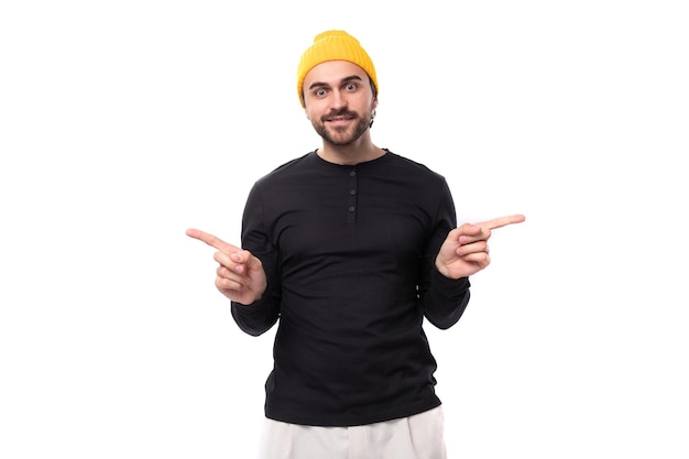 Young stylish brunette european brutal man in a black sweatshirt demonstrates an idea