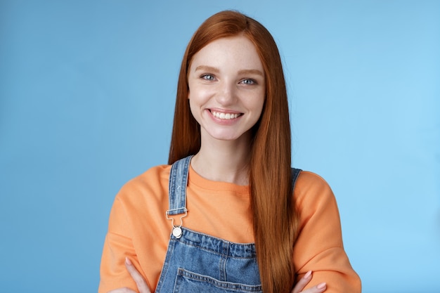 Young stylish confident smiling female redhead freelancer assured job done great grinning satisfied hold hands crossed chest self-assured standing blue background good mood upbeat attitude