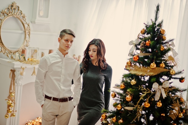 Young stylish couple with Christmas gifts and New Year decoration