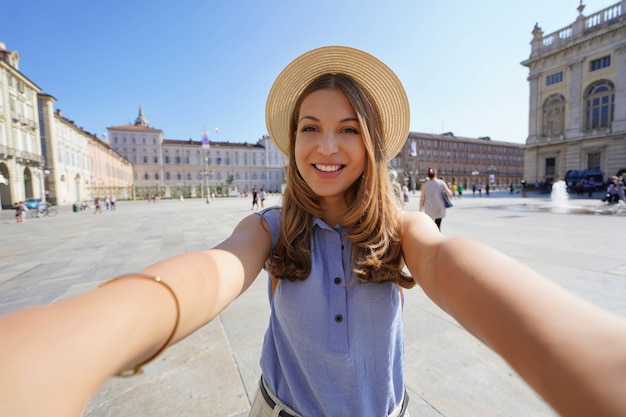 Young stylish girl takes selfie with mobile phone on summer city street urban lifestyle concept