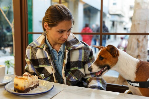 Young stylish girl with a dog in a cafe