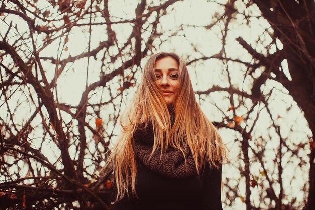 Young stylish girl with long hair outdoors. Student girl posing in autumn park. Autumn fashion, people, lifestyle