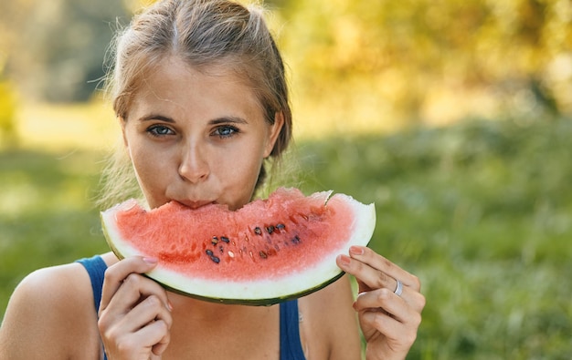 Young stylish lady in the park with a watermelon