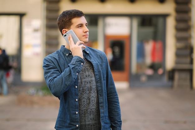 Photo young stylish man stand in centre of the city man call somebody