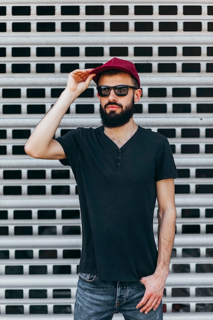 Photo a young stylish man with a beard in a black tshirt and glasses