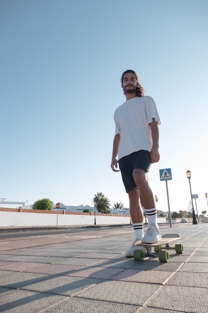 Young stylish skater standing on the street