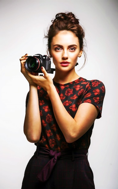 Young stylish woman photographer posing with a camera