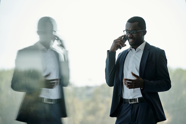 Young successful african american businessman or entrepreneur with mobile phone