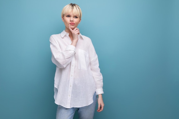 Young successful blond career woman in a white shirt on a blue background with copy space career