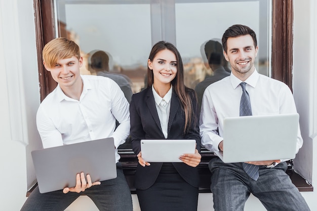 Young successful business people with laptops in their hands on the street