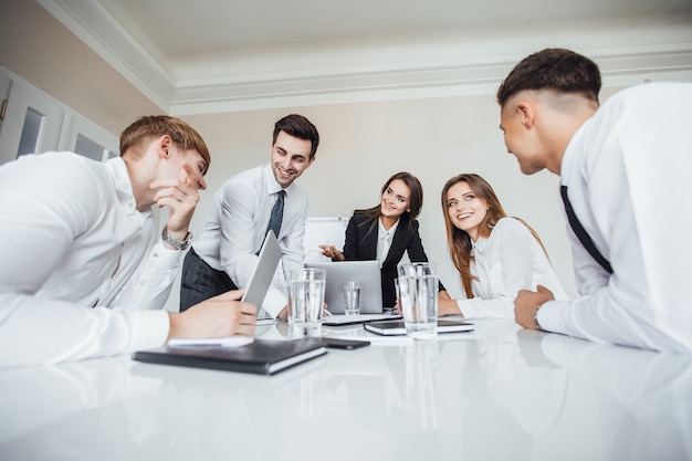 The young successful business team at the meeting smiles and discuss business