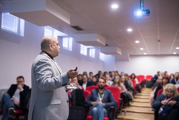 young successful businessman at business conference room with public giving presentations. Audience at the conference hall. Entrepreneurship club