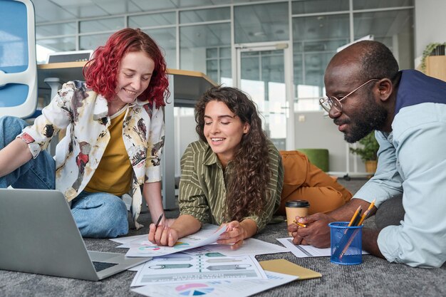 Photo young successful female broker analyzing financial document among coworkers