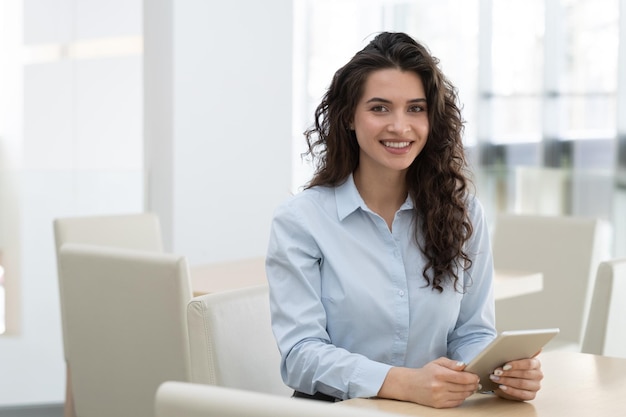 Young successful female specialist with toothy smile working by desk