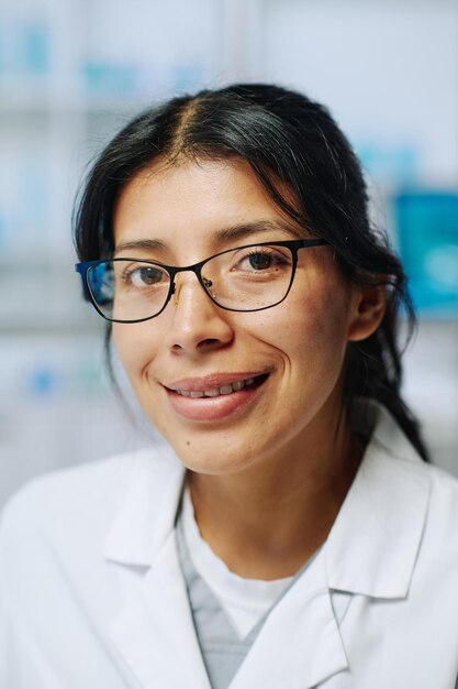 Young successful hispanic female biochemist in eyeglasses and whitecoat