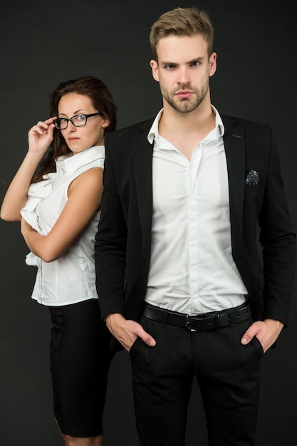 Young and successful Professional couple dark background Businessman and businesswoman in formal wear Professional occupation and career Business activities