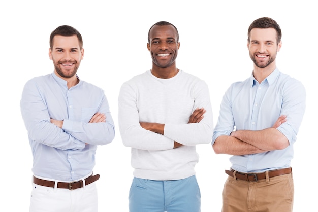 Young and successful. Three confident young men in smart casual wear keeping arms crossed and smiling while standing against white background