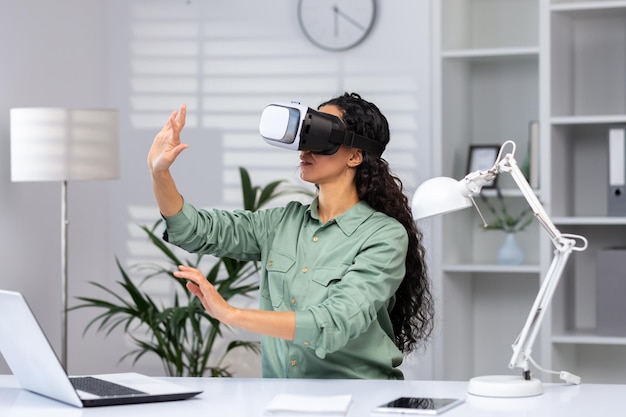 Young successful woman inside the office using vr glasses virtual reality simulator cross charts and