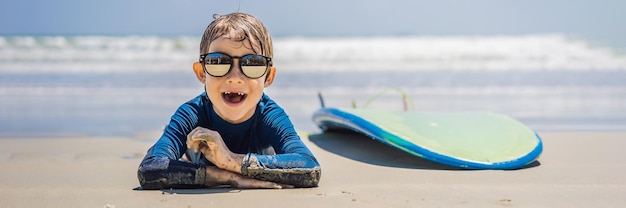 Young surfer happy young boy at the beach with surfboard BANNER LONG FORMAT