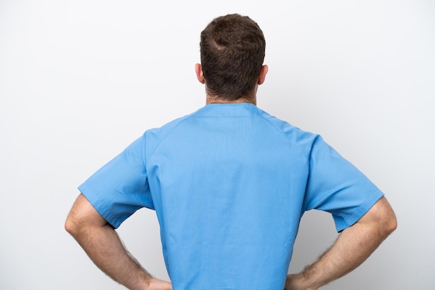 Young surgeon doctor caucasian man isolated on white background in back position