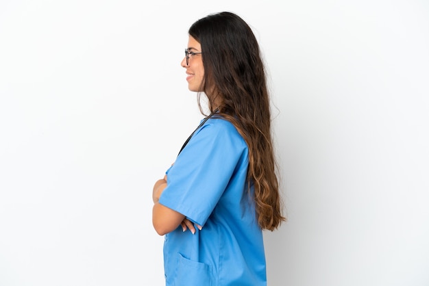 Young surgeon doctor caucasian woman isolated on white background in lateral position