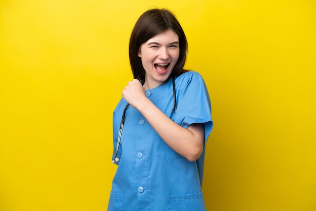 Young surgeon doctor Russian woman isolated on yellow background celebrating a victory