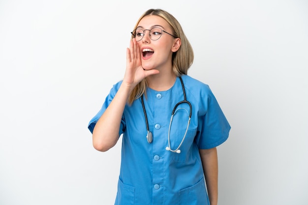 Young surgeon doctor woman isolated on white background shouting with mouth wide open to the side