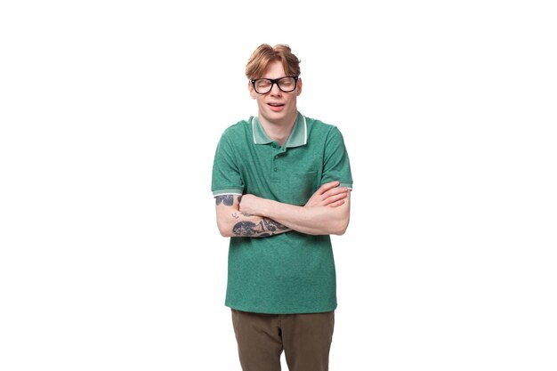 Photo young surprised caucasian man with red hair dressed in a green tshirt crossed his arms in front of