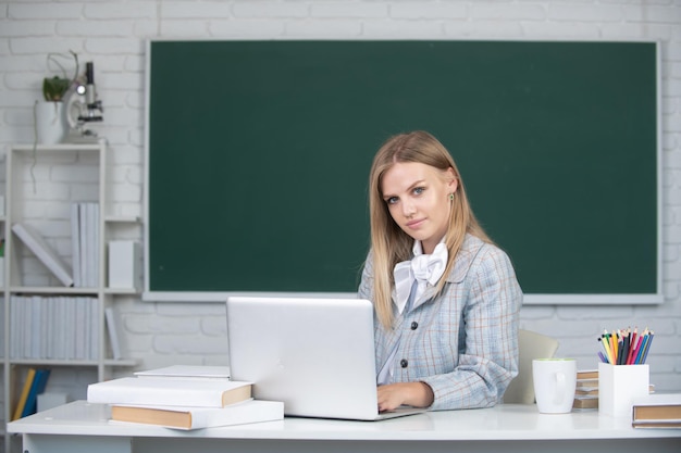 Young teacher female college student working on a laptop in classroom preparing for an exam