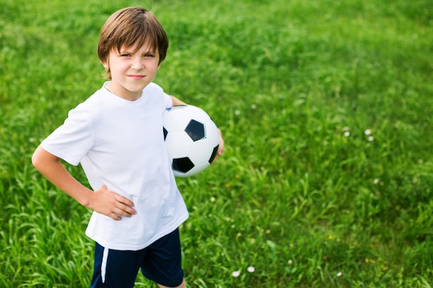 Young teen boy in the playing field In Football Team