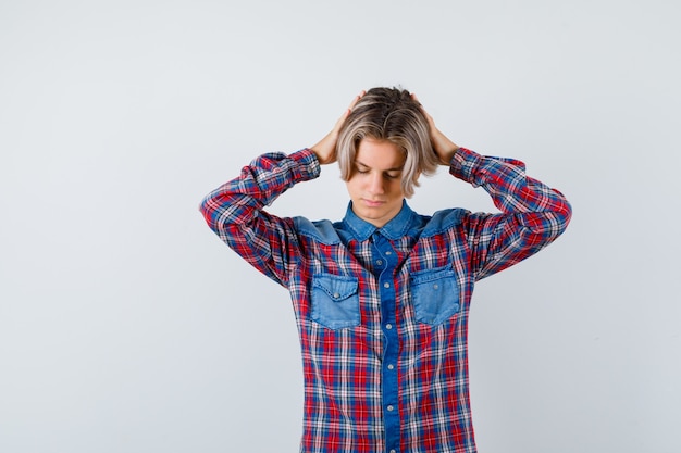 Young teen boy with hands on head