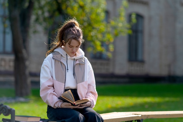 Young teenage girl relaxing reading in a park