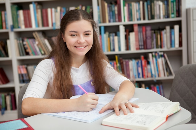 Young teenage girl studying at the library