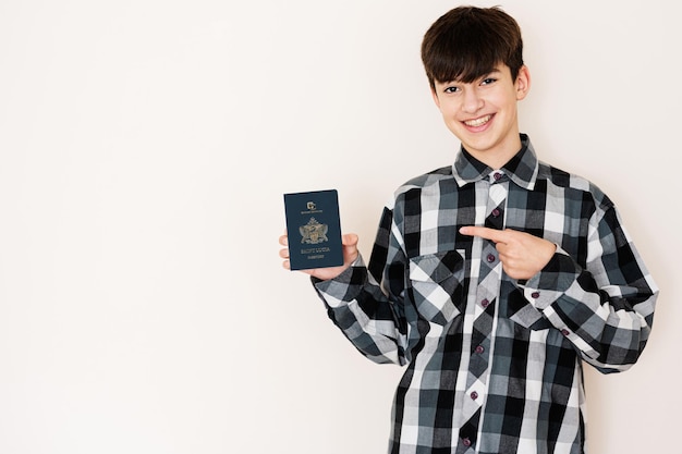 Young teenager boy holding Saint Lucia passport looking positive and happy standing and smiling with a confident smile against white background