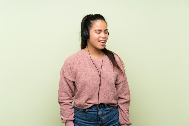 Young teenager girl listening to music with headphones