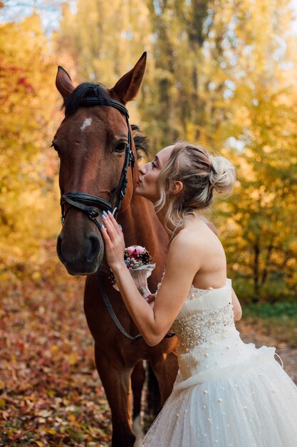 Young tender bride girl posing near in the autumn forest