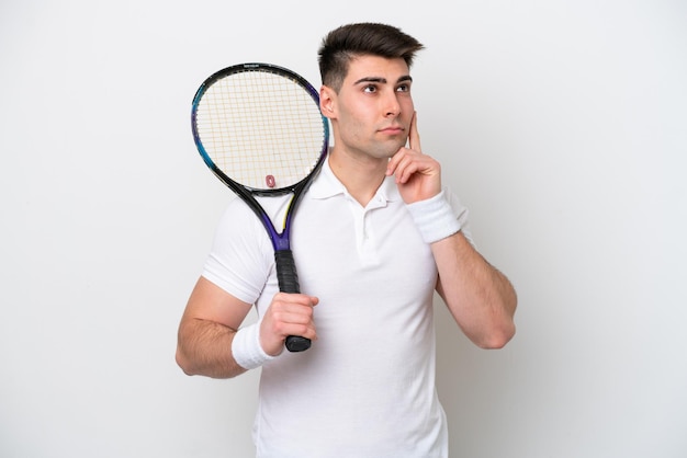 Young tennis player man isolated on white background having doubts and thinking