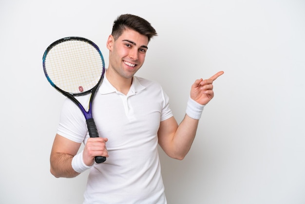 Young tennis player man isolated on white background pointing finger to the side