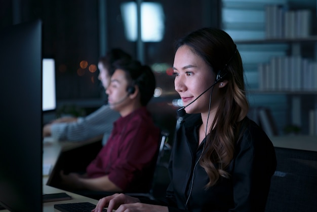 Young Thai Asian customer services care operators working night shift in call center