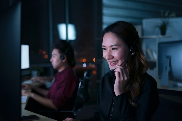 Young Thai Asian customer services care operators working night shift in call center