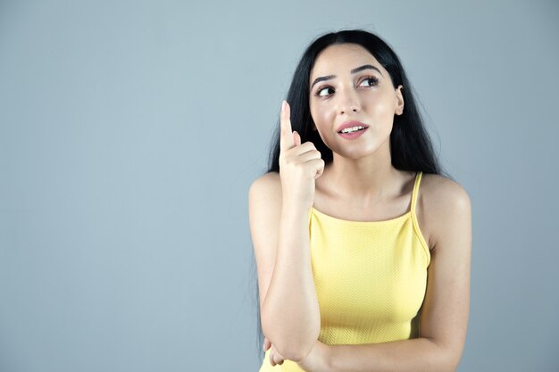 The young thinking woman on grey